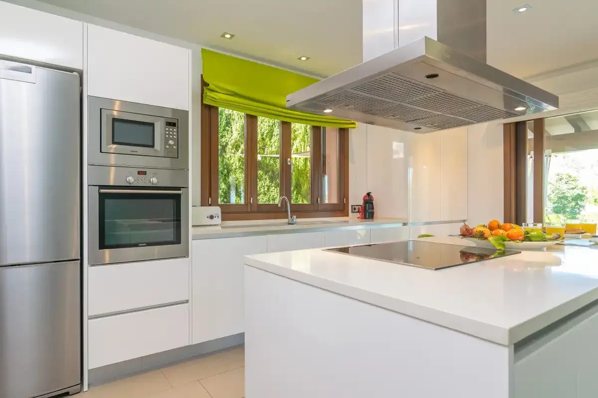A bright modern kitchen has white cabinets and a large central island.
