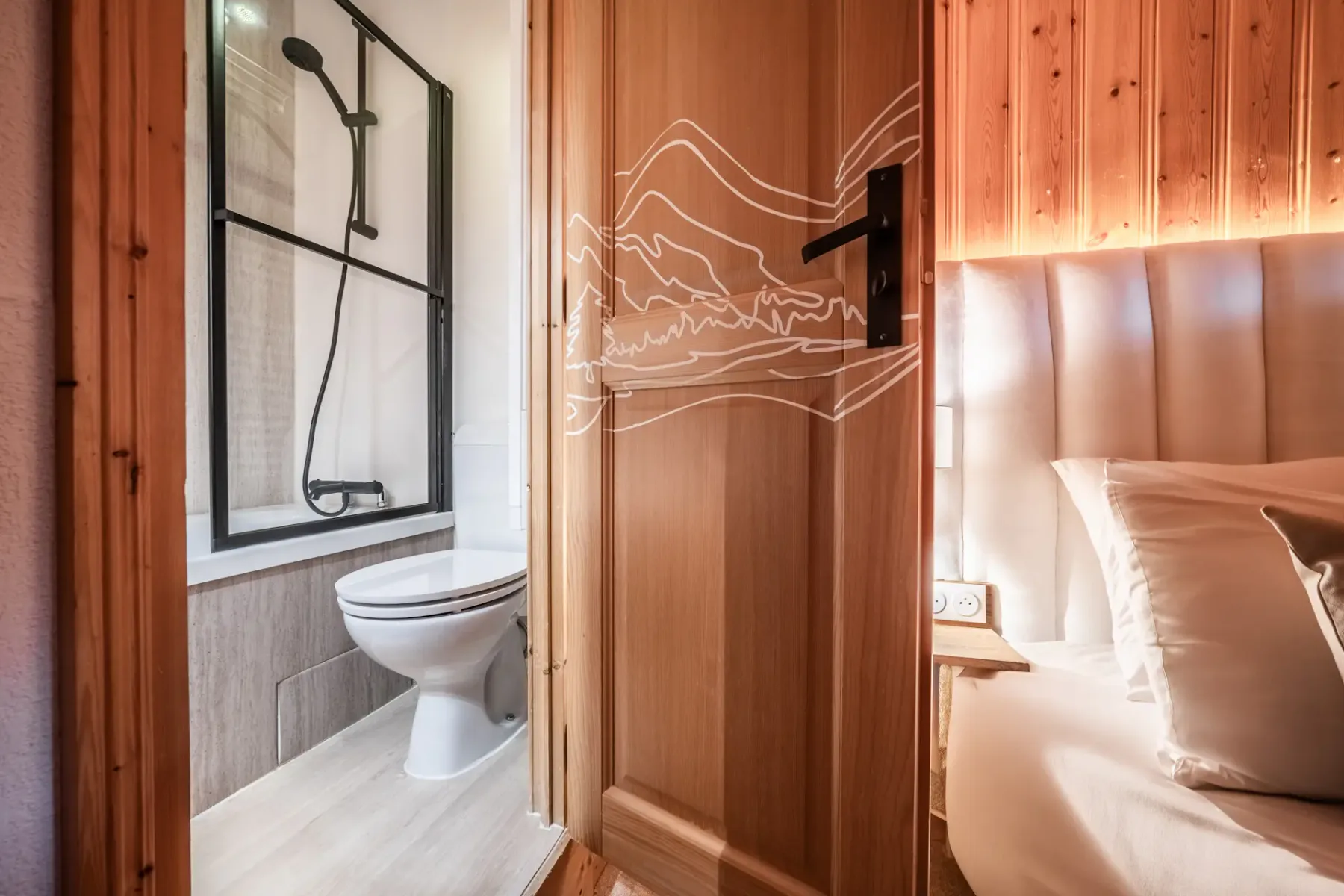 A modern bathroom with a wooden ceiling, wall mirror, round sink, and a bathtub with a glass partition.