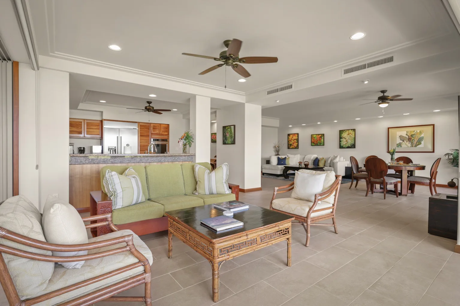 A bright open-plan living and dining area has cushioned seating and a wooden dining table.