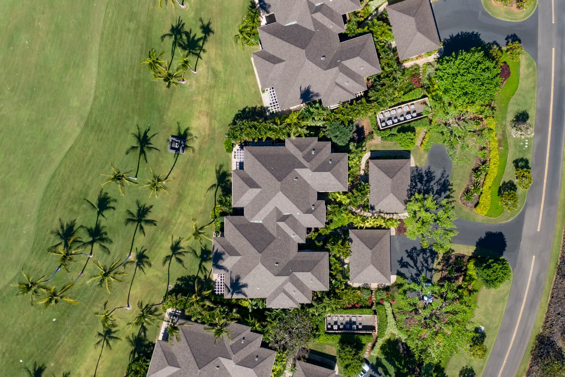 An aerial view of buildings and landscaped grounds beside a road.