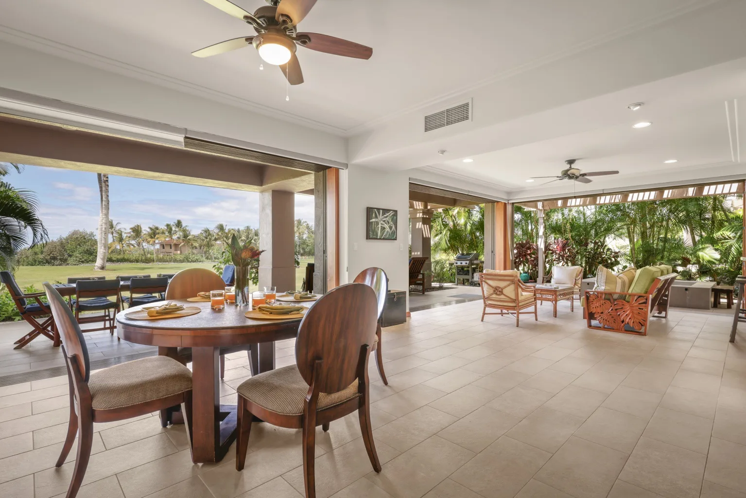An open dining and sitting area with a table and garden views.