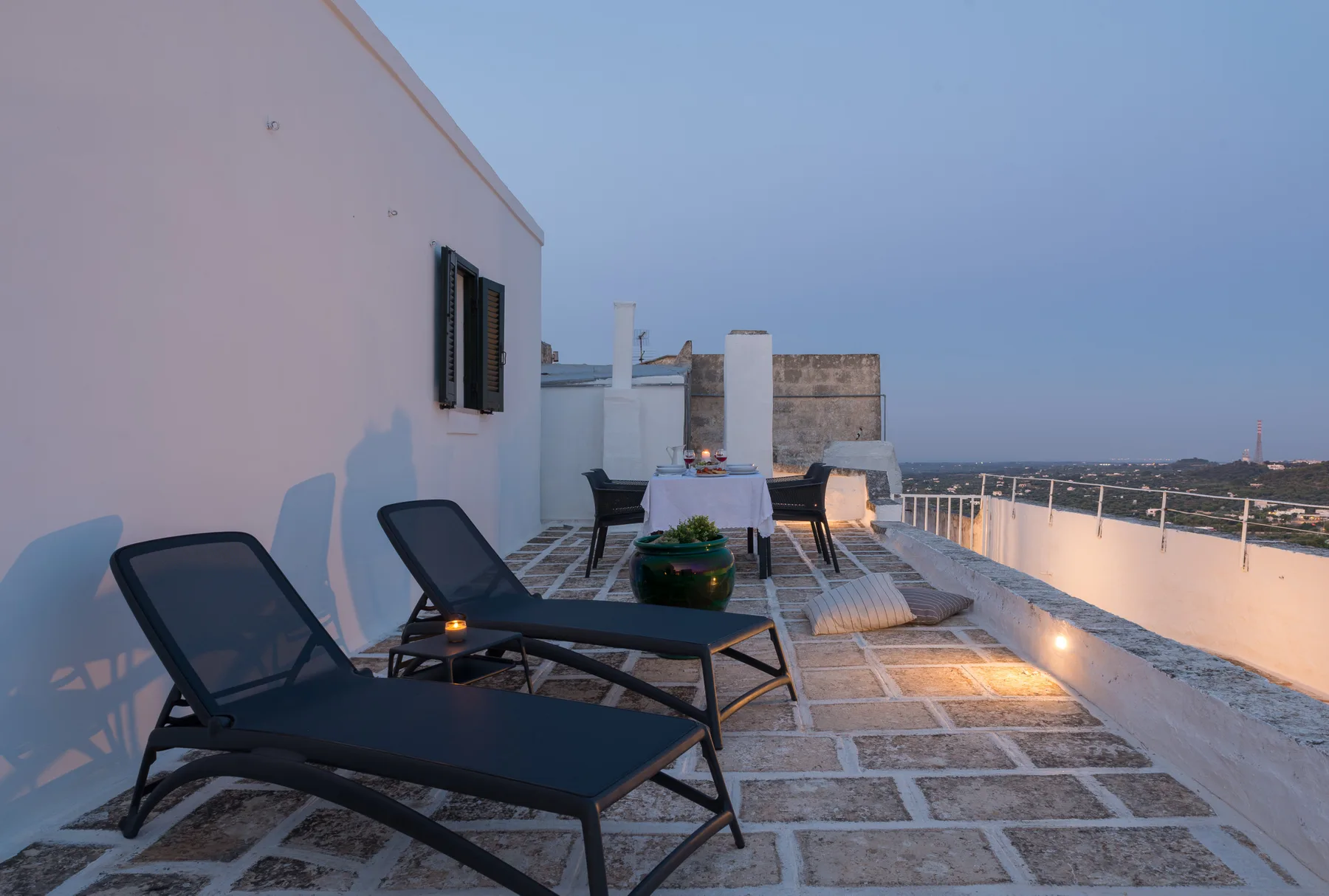 Una terraza en la azotea con asientos de descanso y vistas al paisaje circundante.