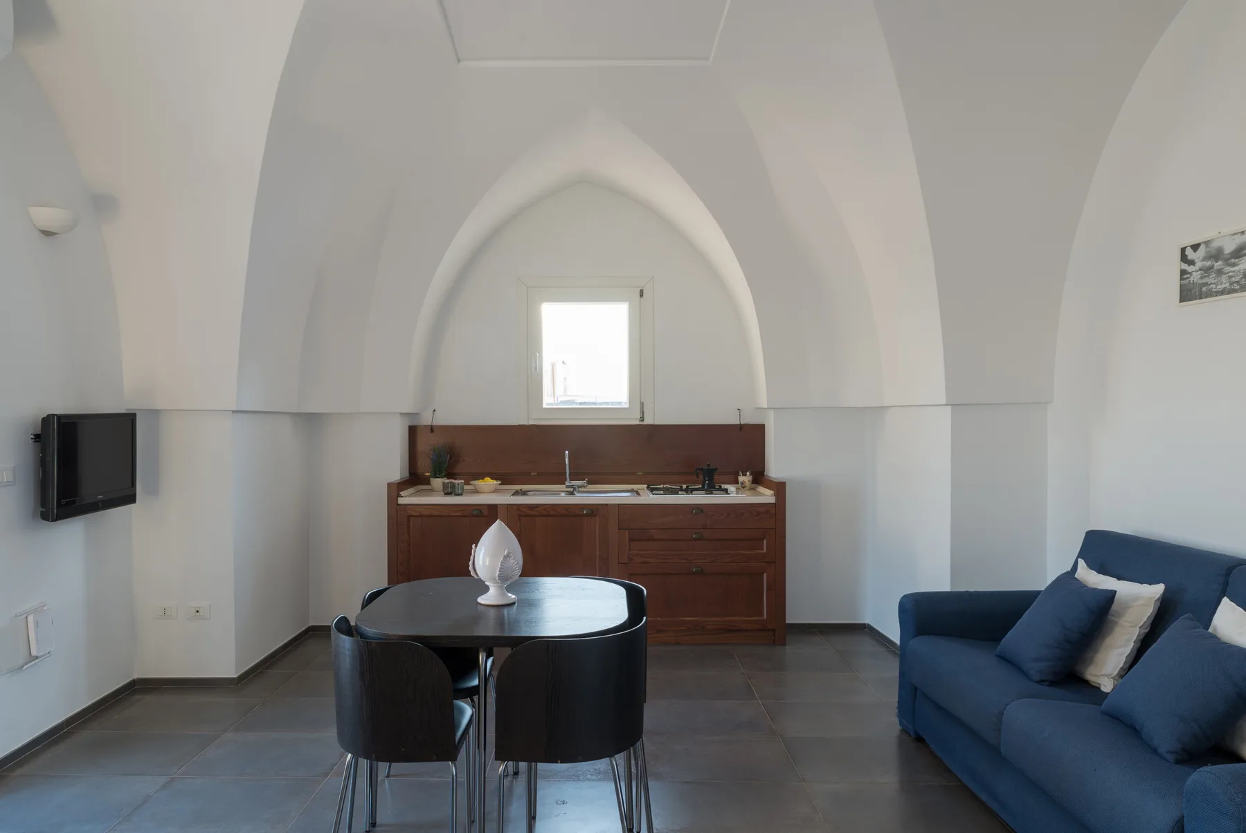 Sala de estar y comedor con una mesa, sillas y asientos azules.