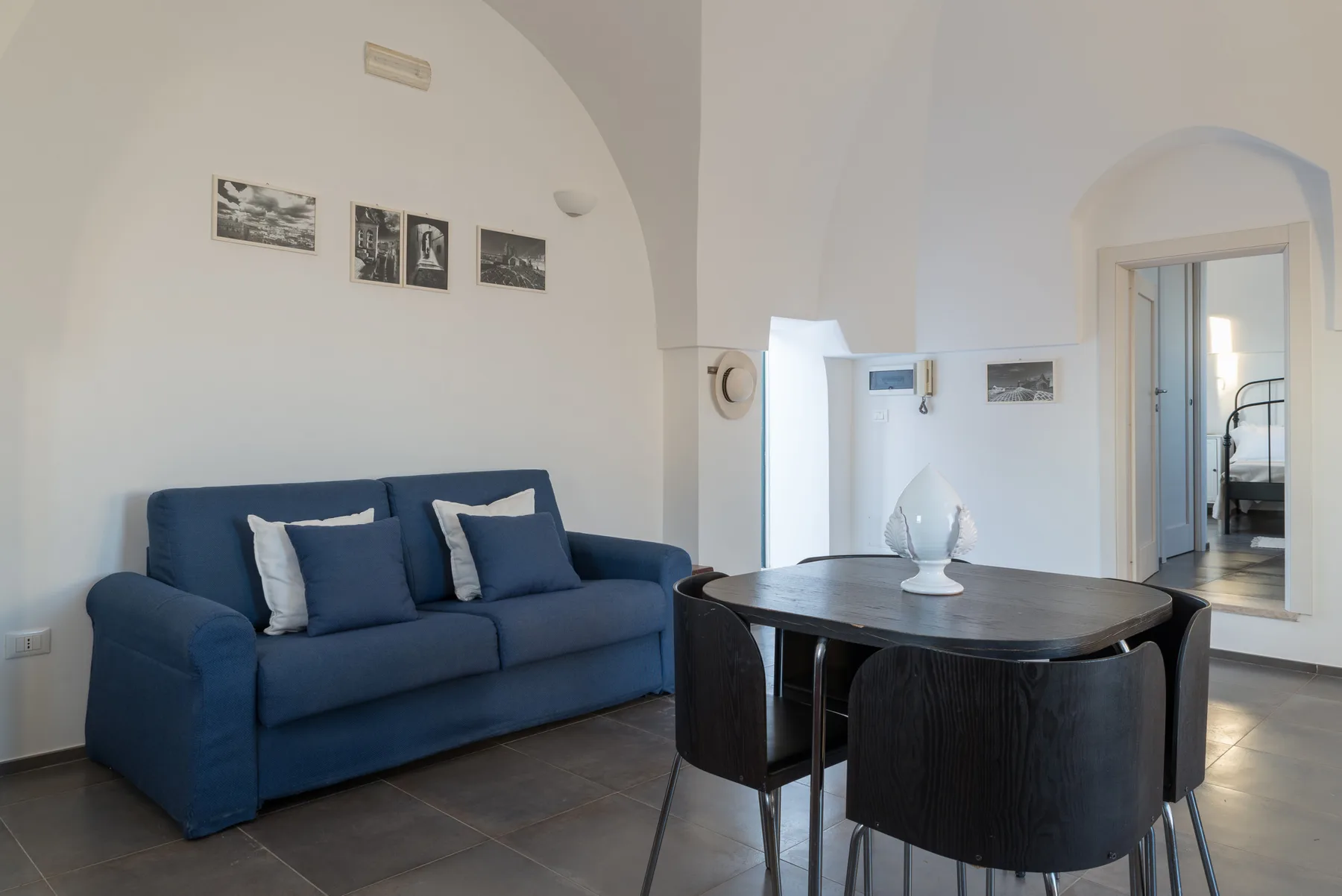 Una sala de estar con asientos azules y una mesa de comedor oscura.