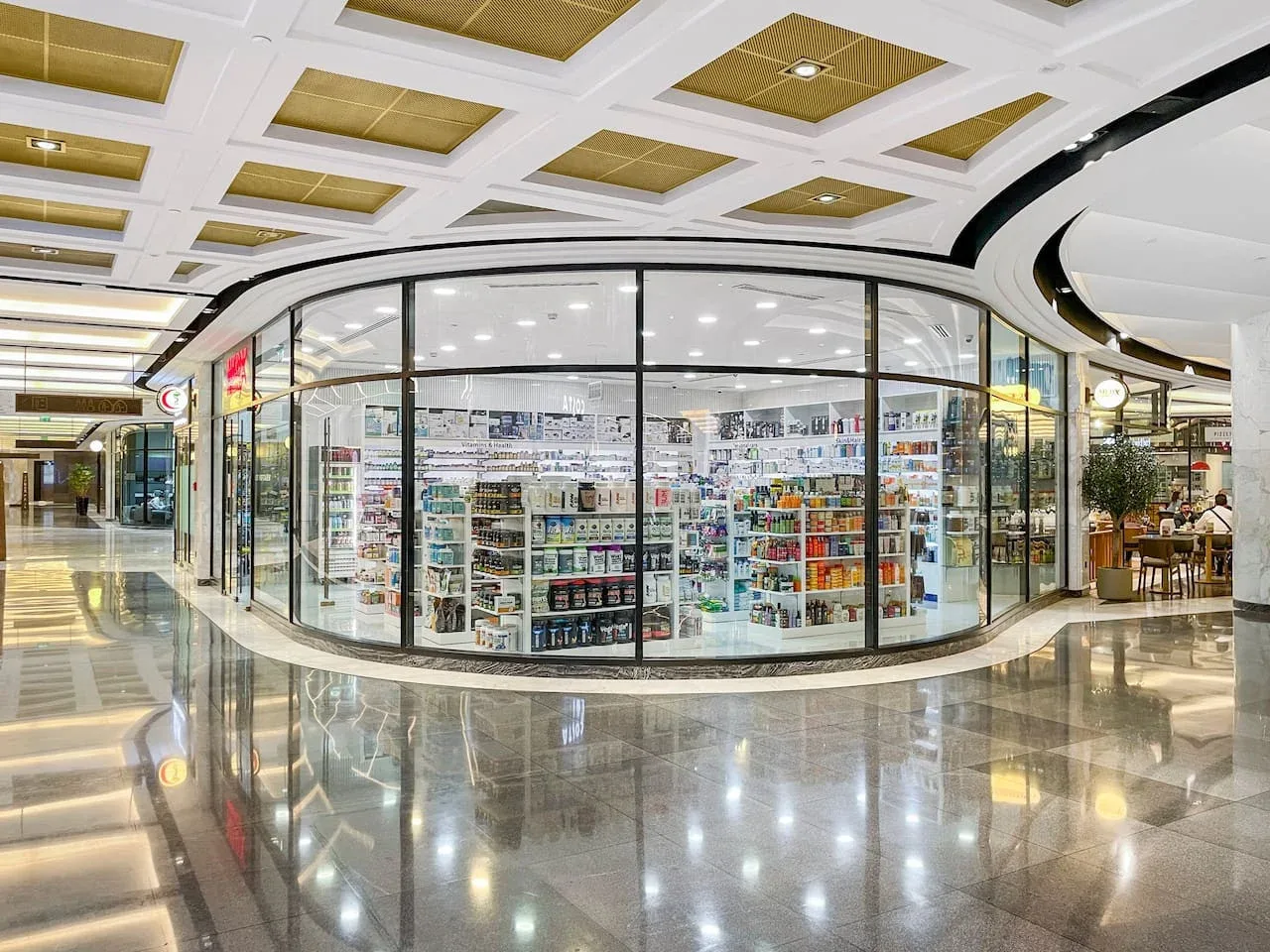 Una tienda bien iluminada con paredes de vidrio y estantes de productos en un centro comercial.