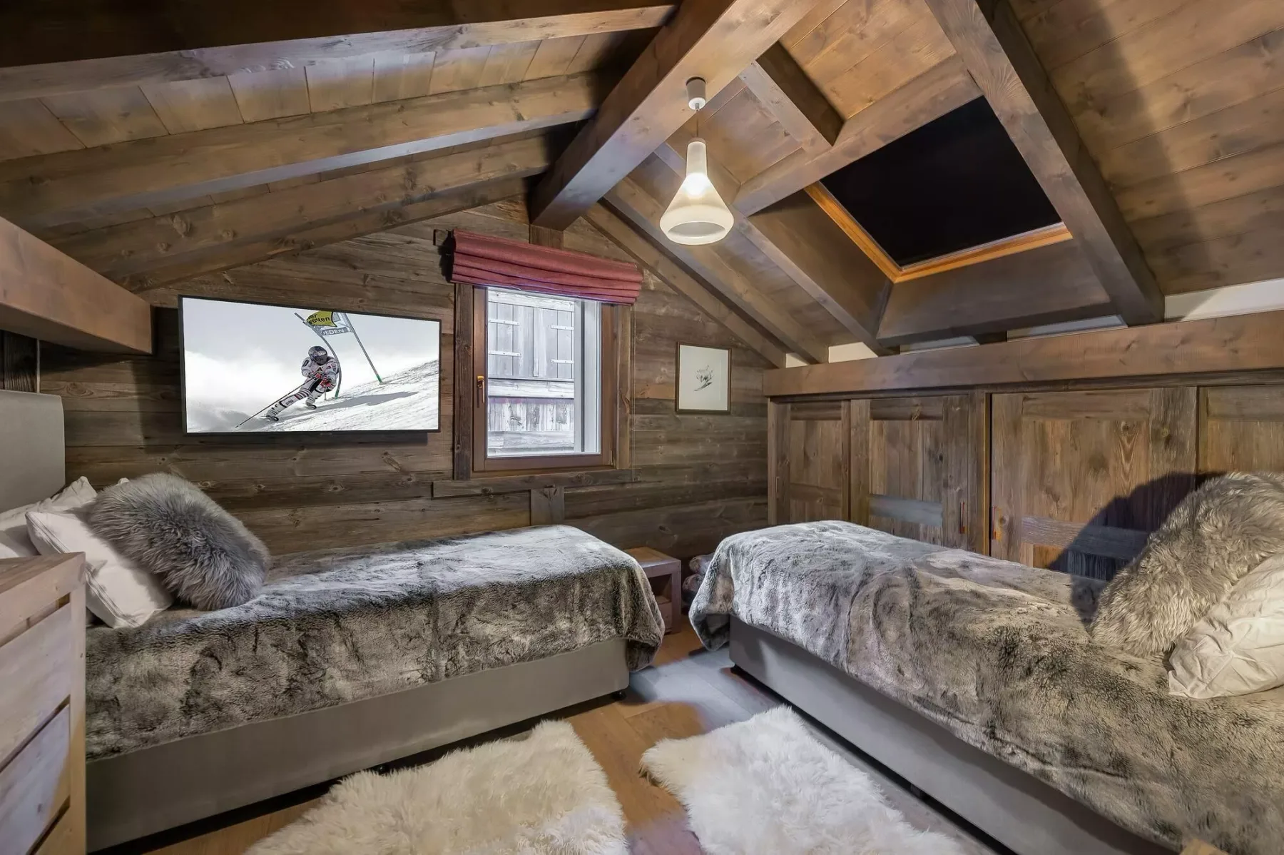 A wood-paneled bedroom with two beds and a small window.