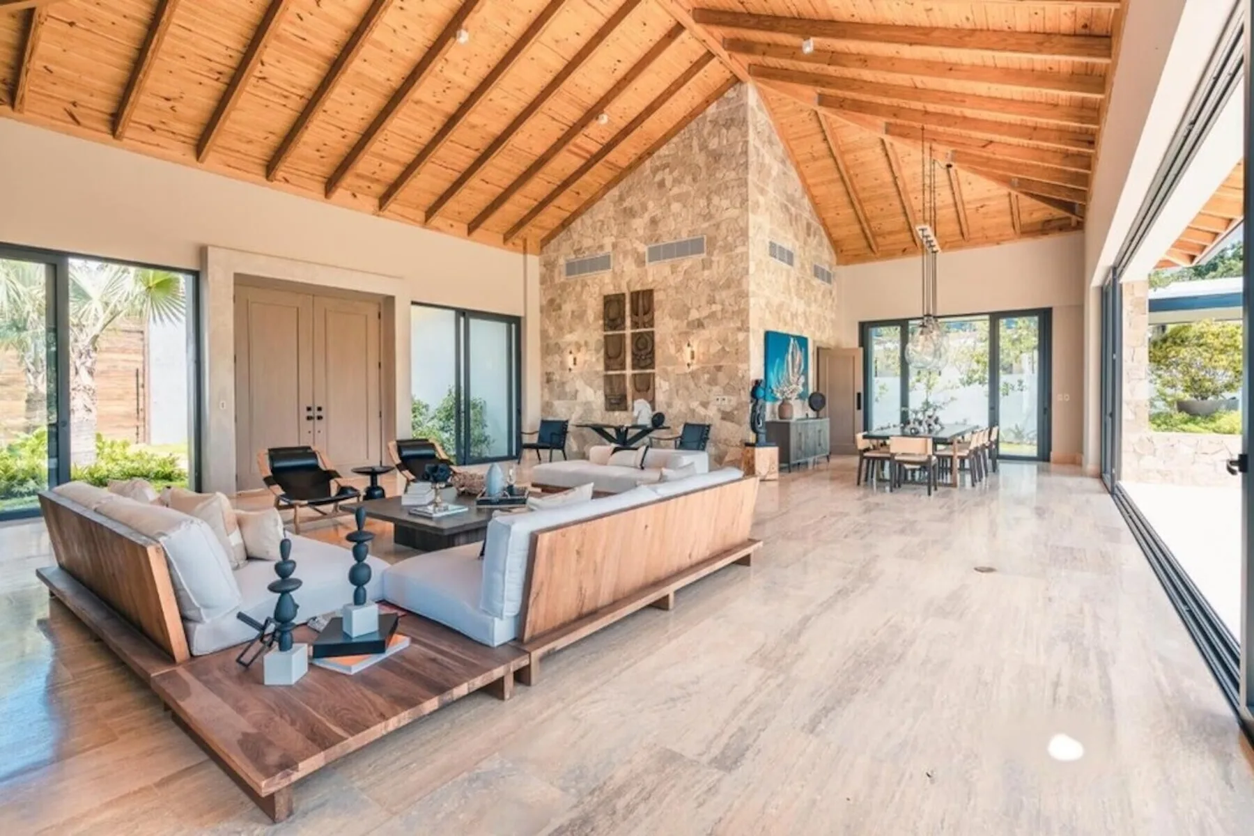 Una amplia sala de estar y comedor con asientos bajo un techo de madera.