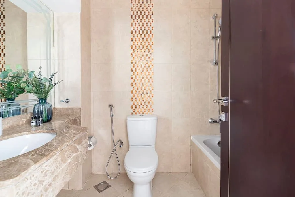 Un baño alicatado con lavabo, inodoro y bañera.