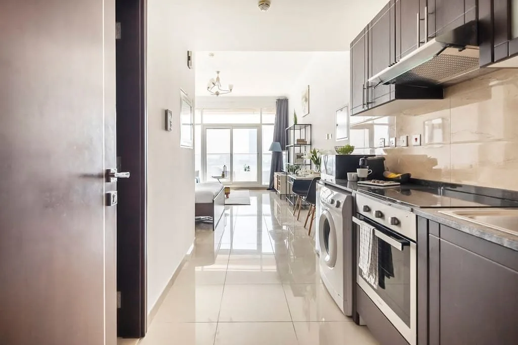 Una cocina luminosa se abre a un comedor y una sala de estar.