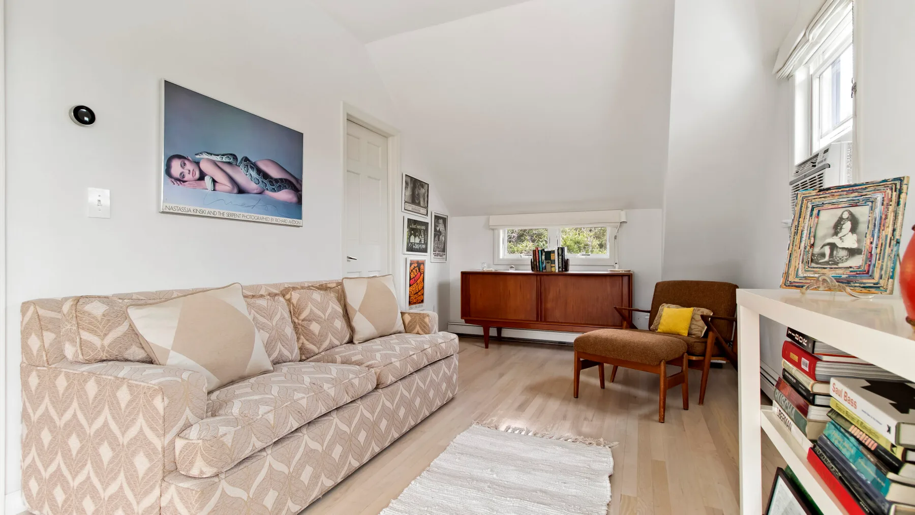 Una sala de estar luminosa con asientos estampados y un mueble de madera.