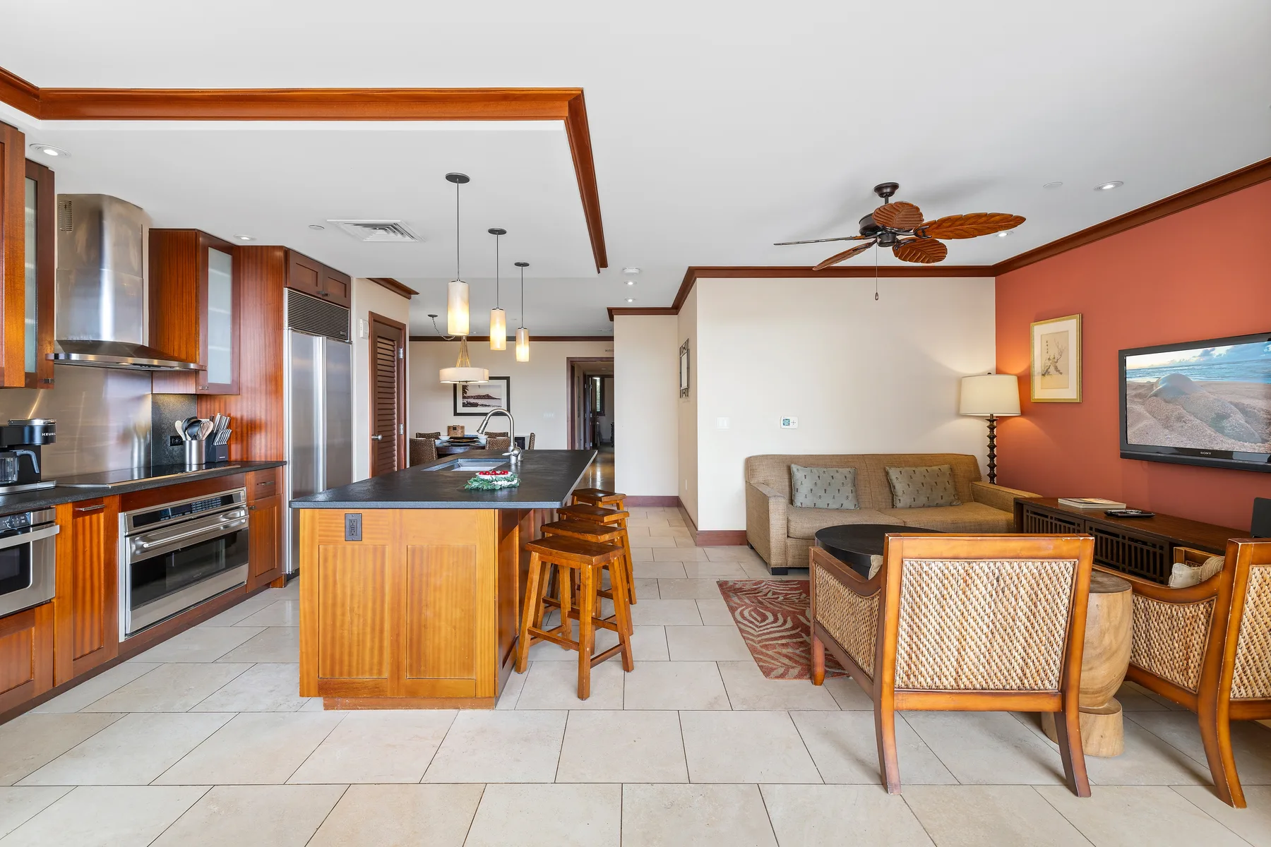 Una cocina abierta al salón, con una isla central y una zona de estar.