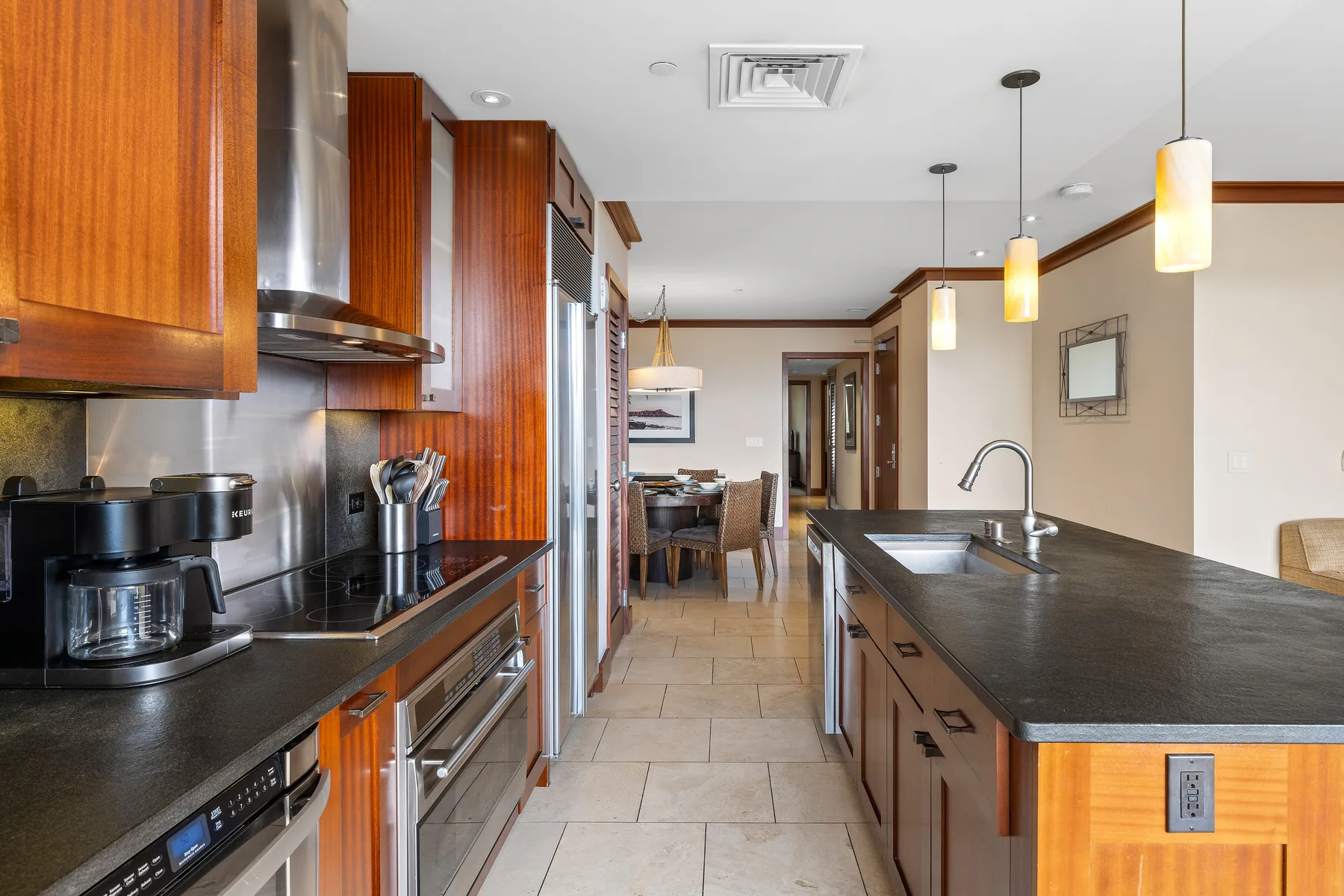 Una cocina moderna con gabinetes de madera, encimeras oscuras y una isla central.