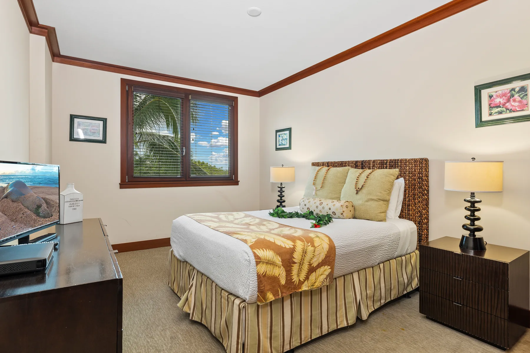 A bedroom with a neatly made bed, bedside lamps, and a window.