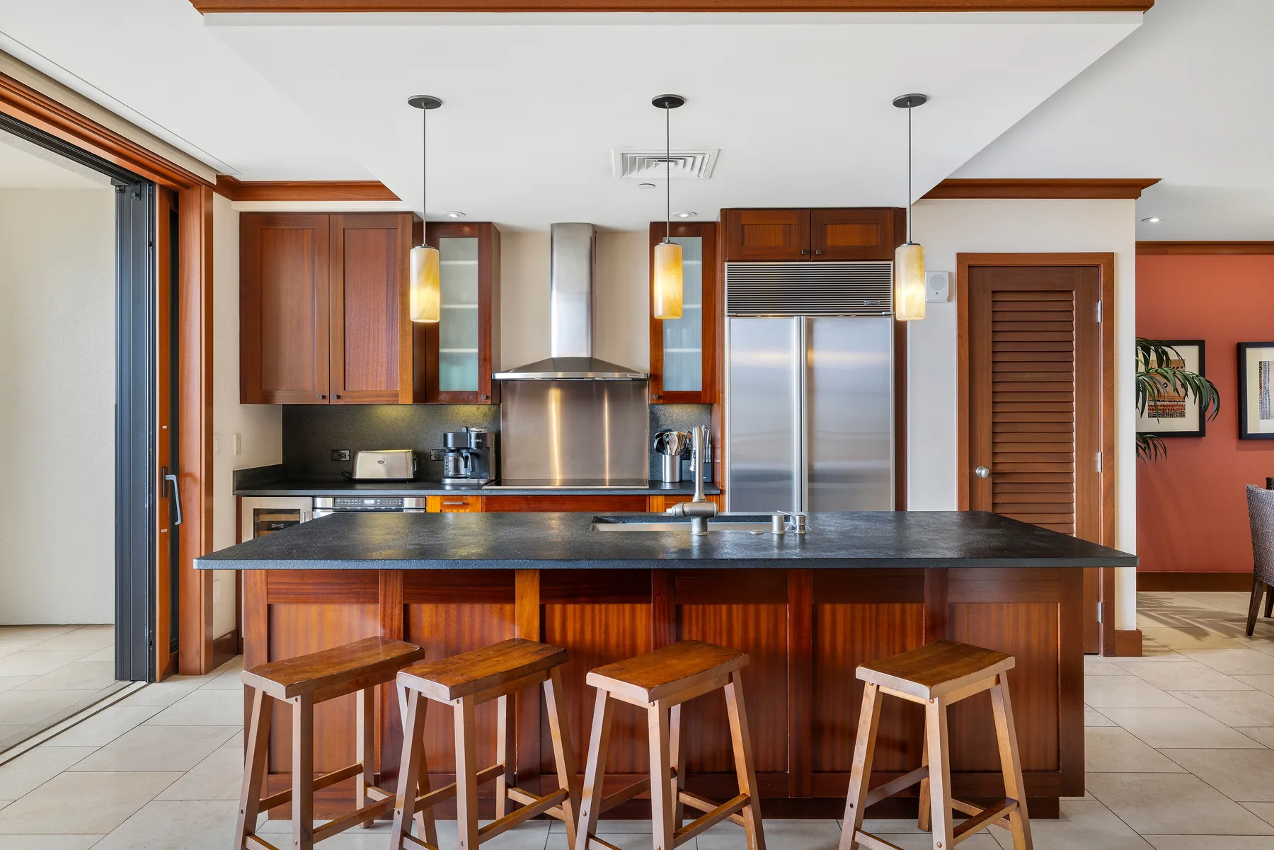 A kitchen with a large island, wooden cabinetry, and seating.