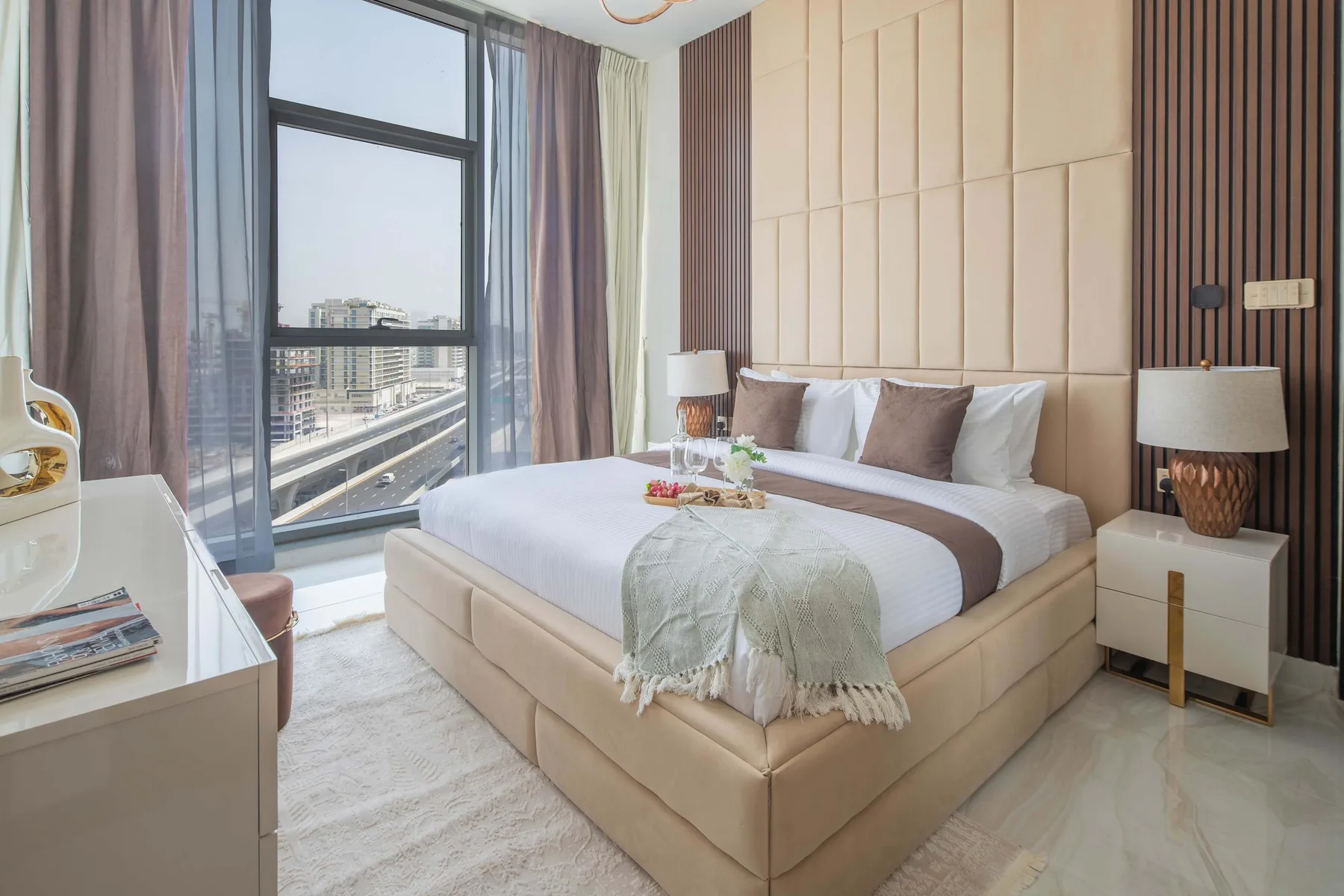 Un dormitorio moderno con una cama grande junto a una ventana de suelo a techo.