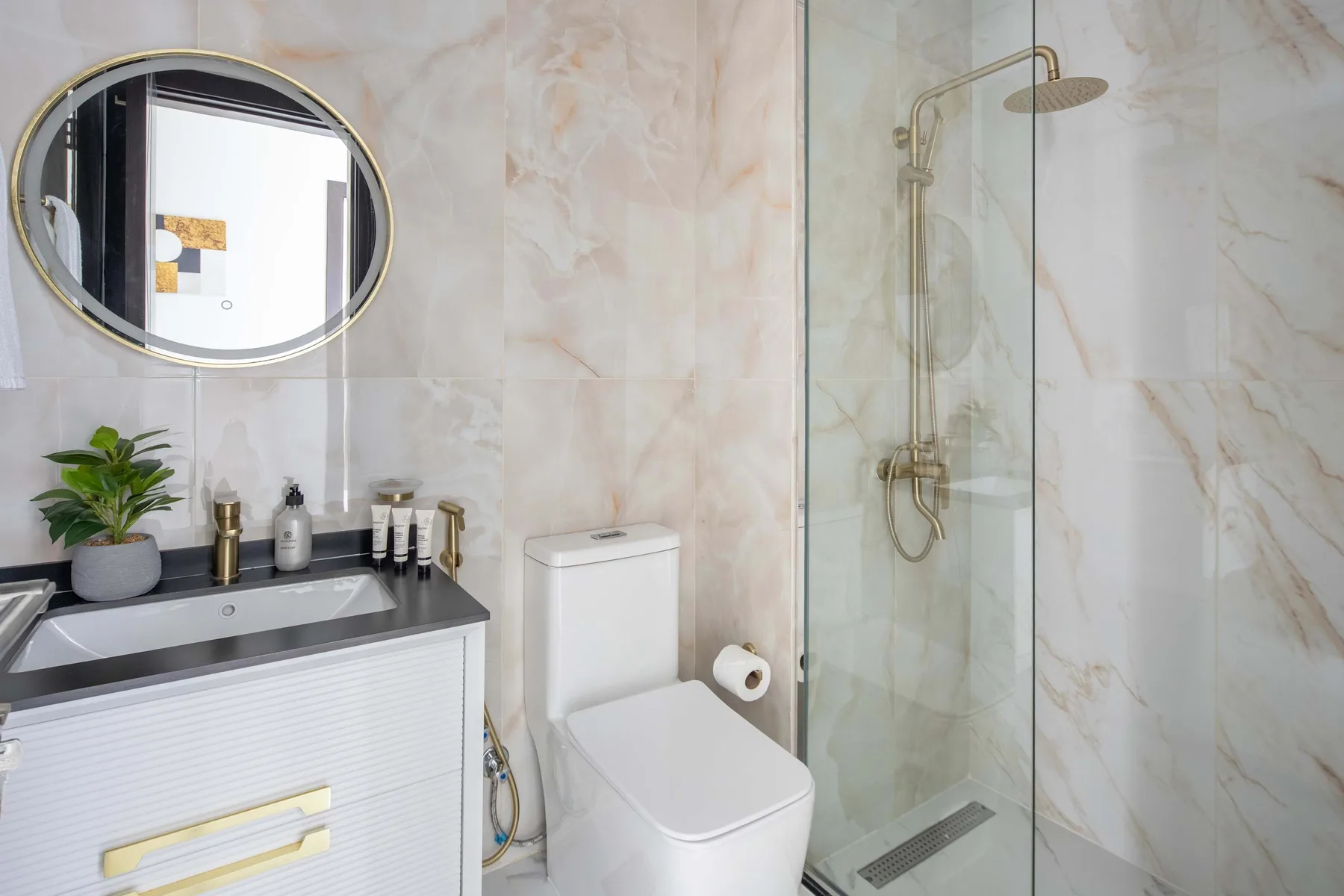Un baño con lavabo, inodoro y ducha de cristal.