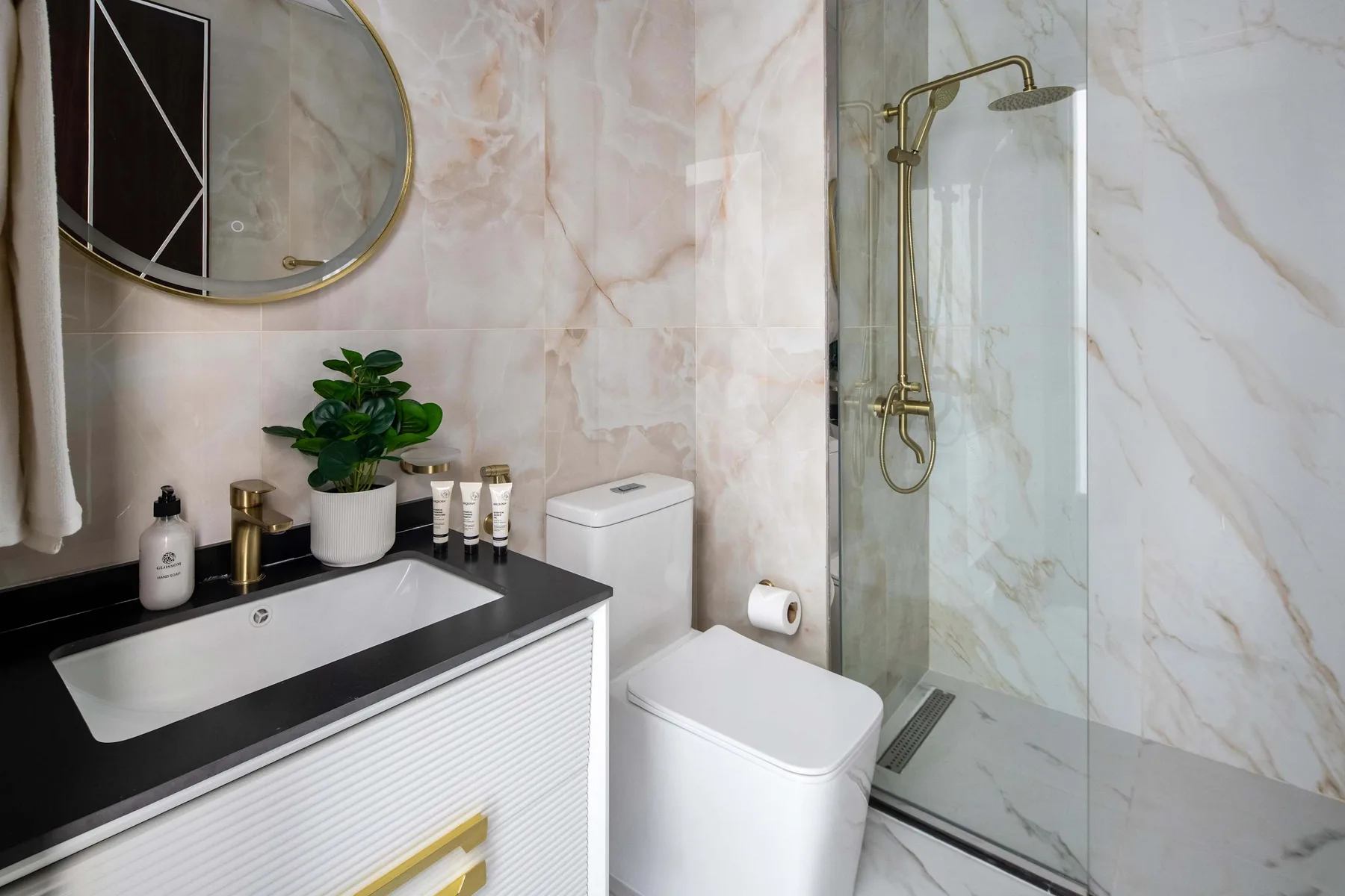 Un baño con lavabo, inodoro y ducha de vidrio.