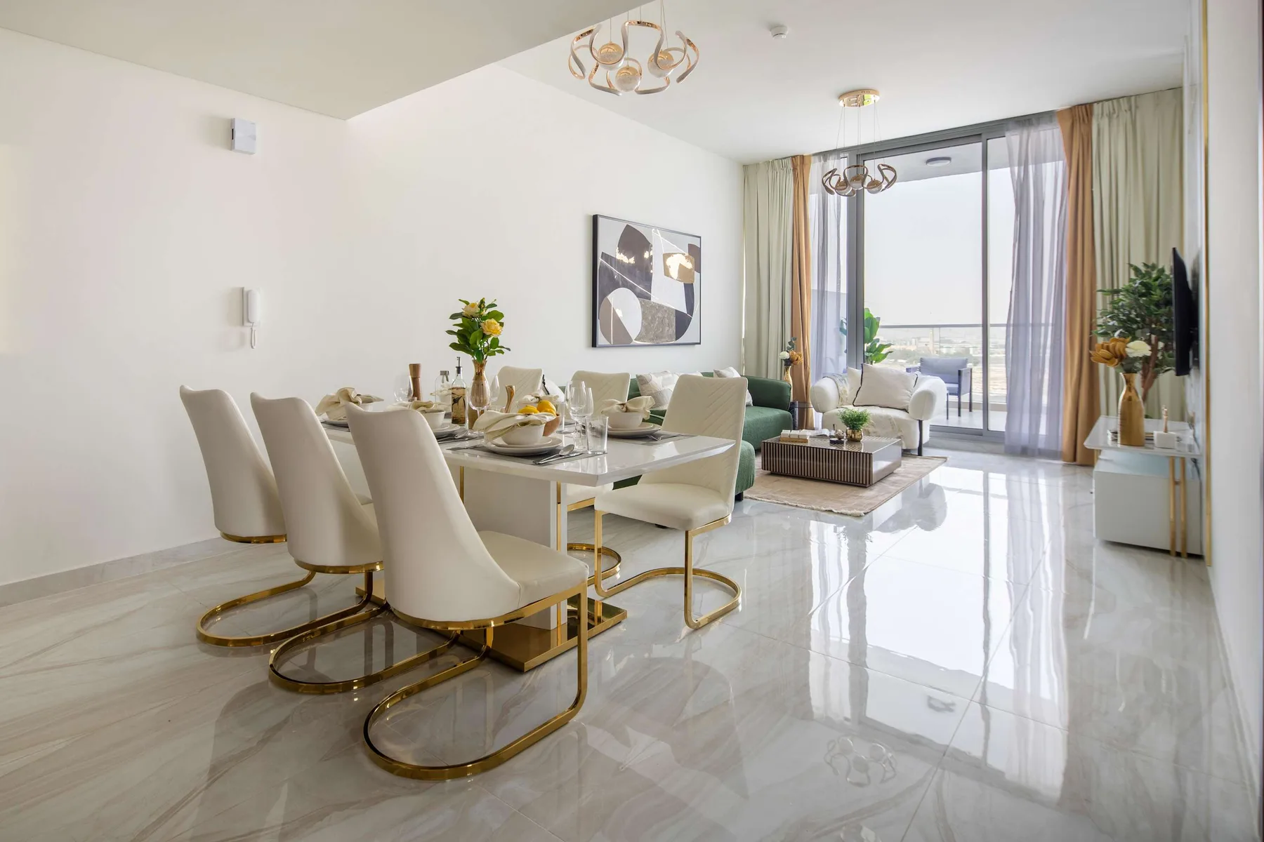 Una luminosa zona de comedor y estar con una mesa junto a grandes ventanales.