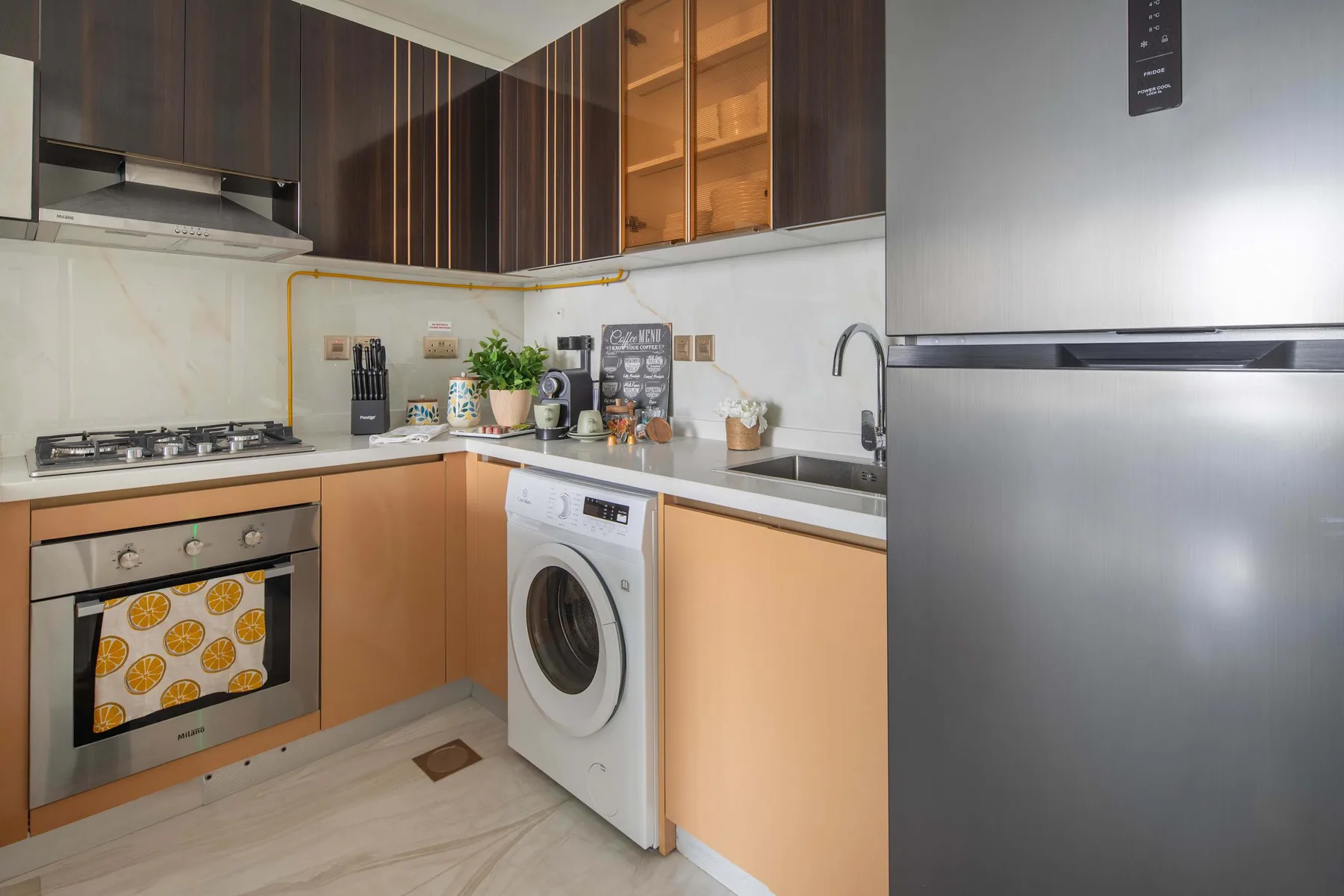 Una cocina moderna con encimera de gas, lavadora y refrigerador.