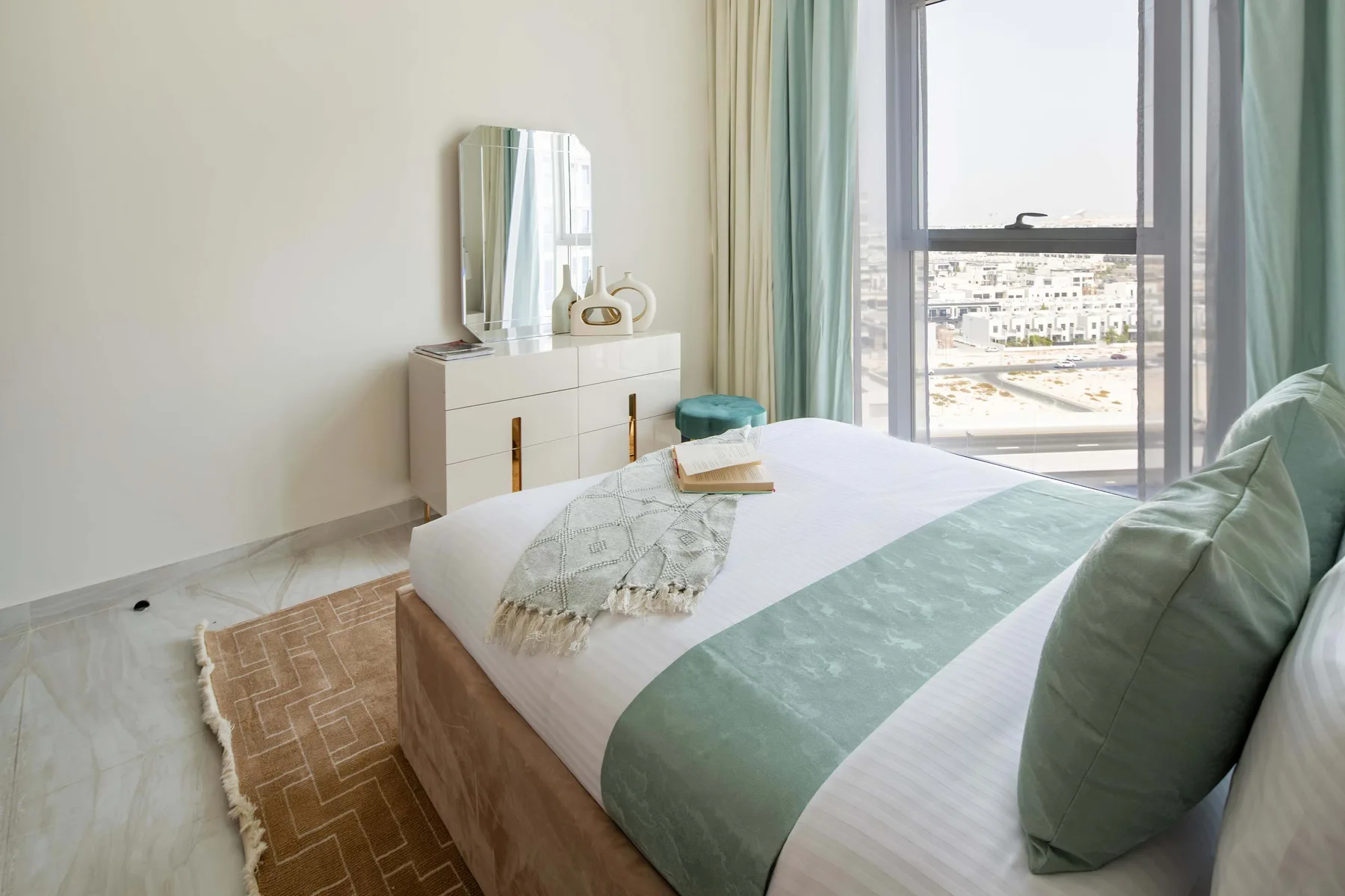 Un dormitorio luminoso con una cama junto a una ventana grande.
