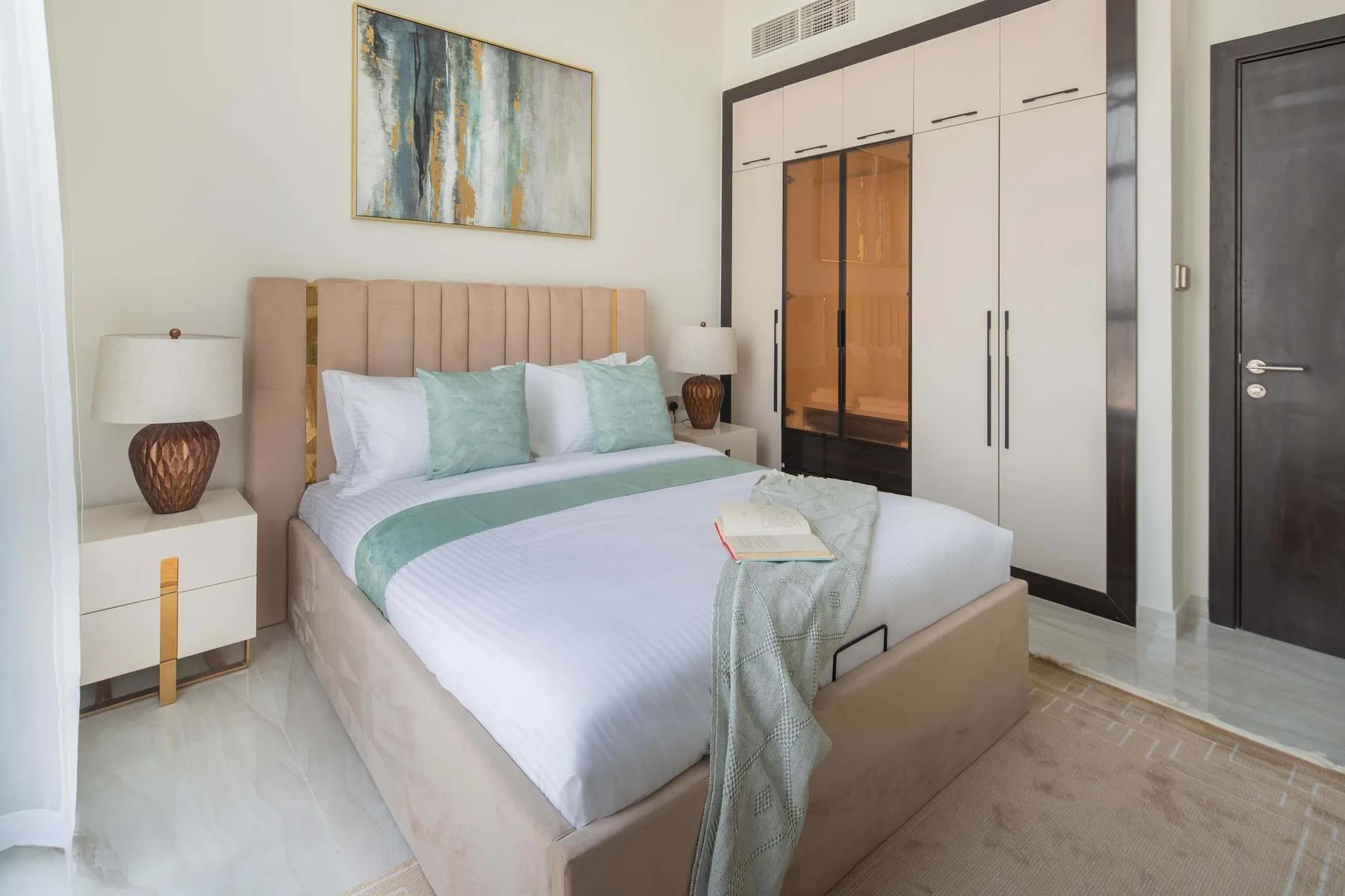Un dormitorio con una cama bien hecha y armarios empotrados.