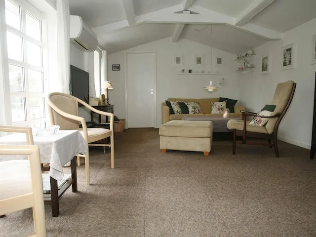 A bright living room with seating around a low table and large windows.