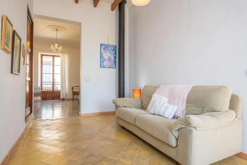 A living room with a beige sofa and tiled floor.