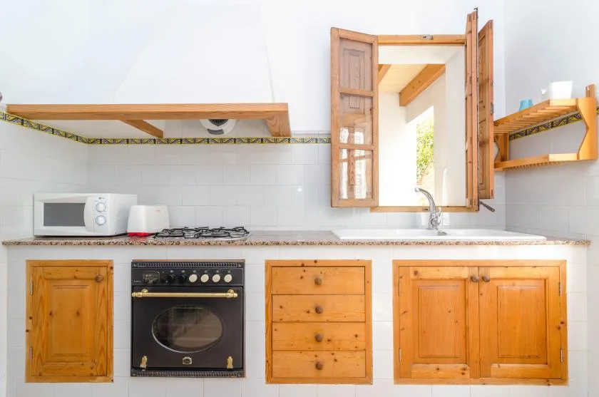 A bright kitchen with wooden cabinets and a window above the sink.