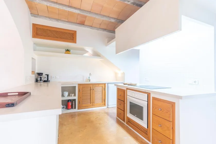 A bright kitchen with wood cabinetry and a built-in oven.