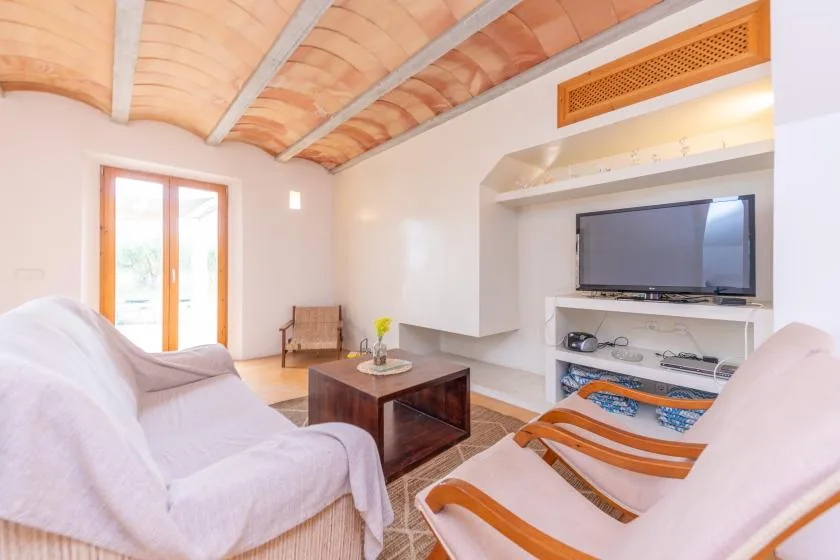 A living room with seating, a coffee table, and a television.