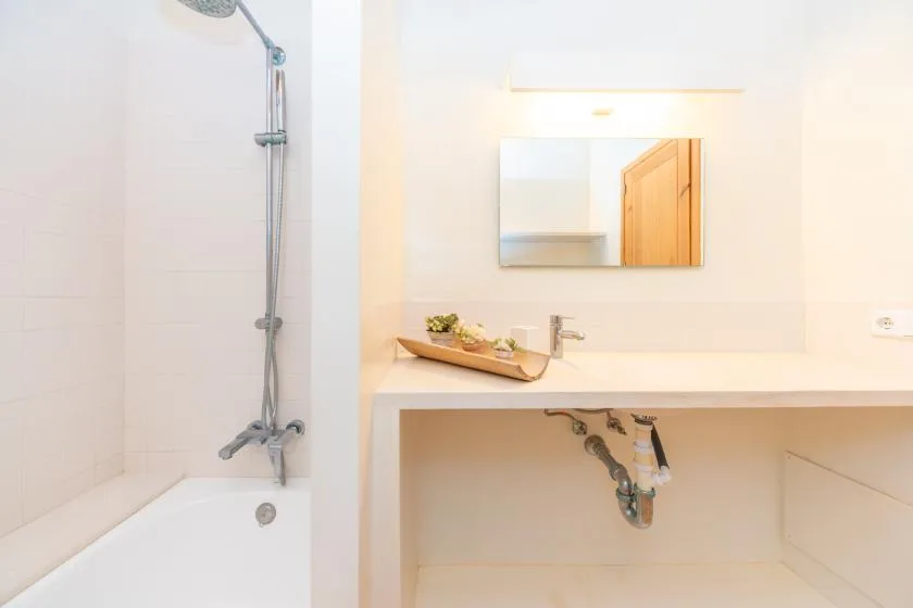 A bright bathroom with a bathtub, shower, and sink vanity.