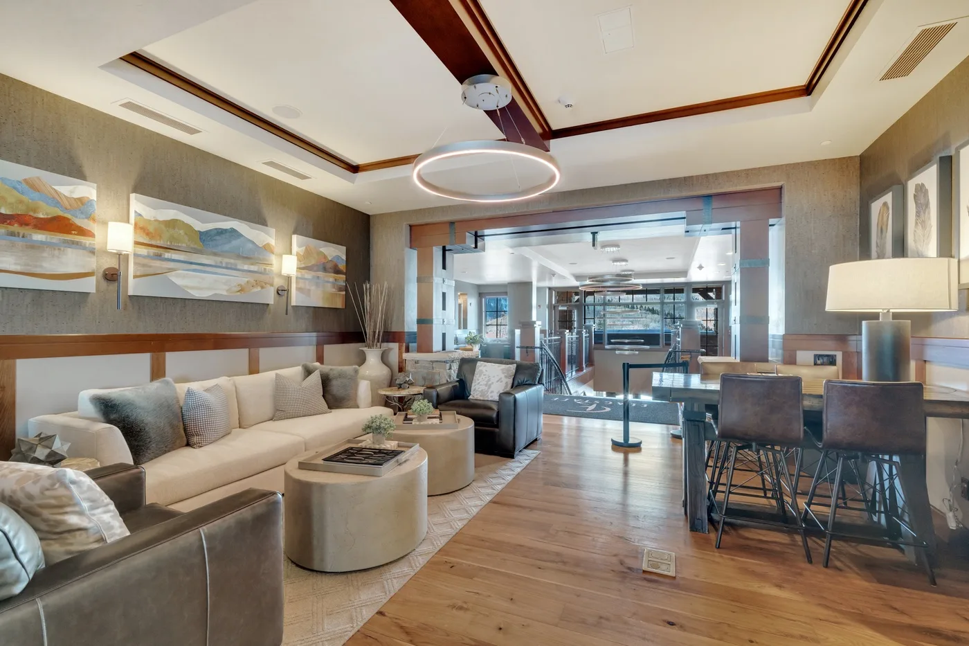 A lounge with seating around a low table and a dining area beyond.