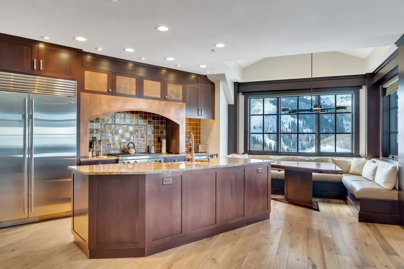 A spacious kitchen with dark wood cabinets, a central island, and a large window.