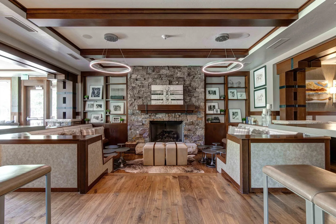 A spacious lounge with a stone fireplace, built-in shelves, and seating.