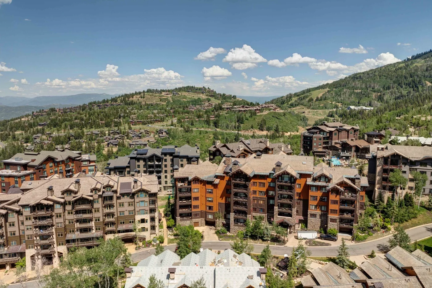 A hillside resort village with clustered buildings beneath a blue sky.