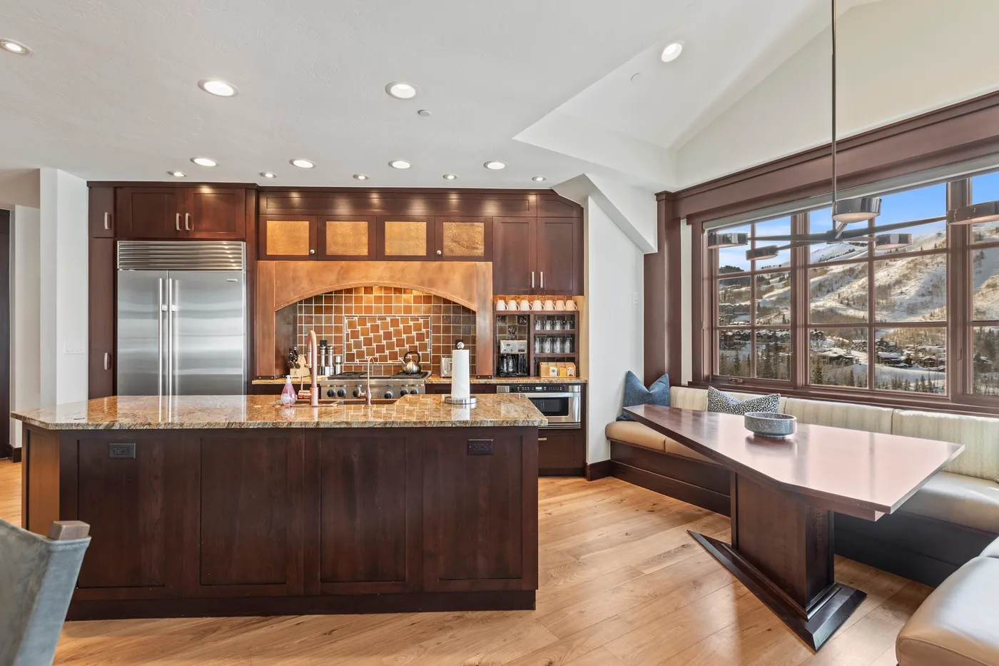 A spacious kitchen with dark cabinetry, a central island, and a large window.
