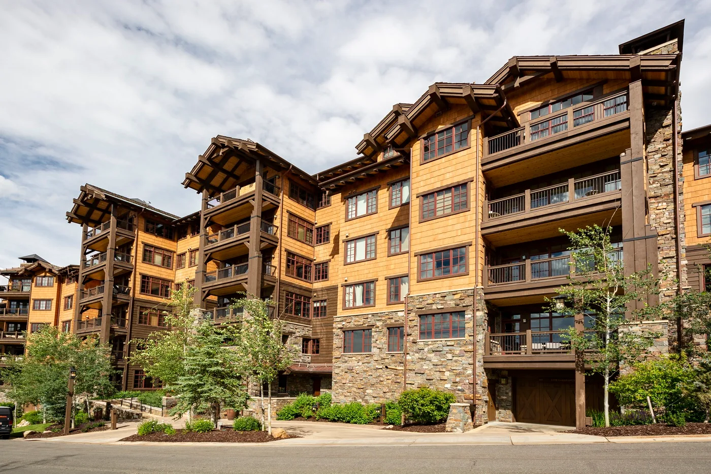 A large multi-story building with balconies stands beside landscaped grounds.