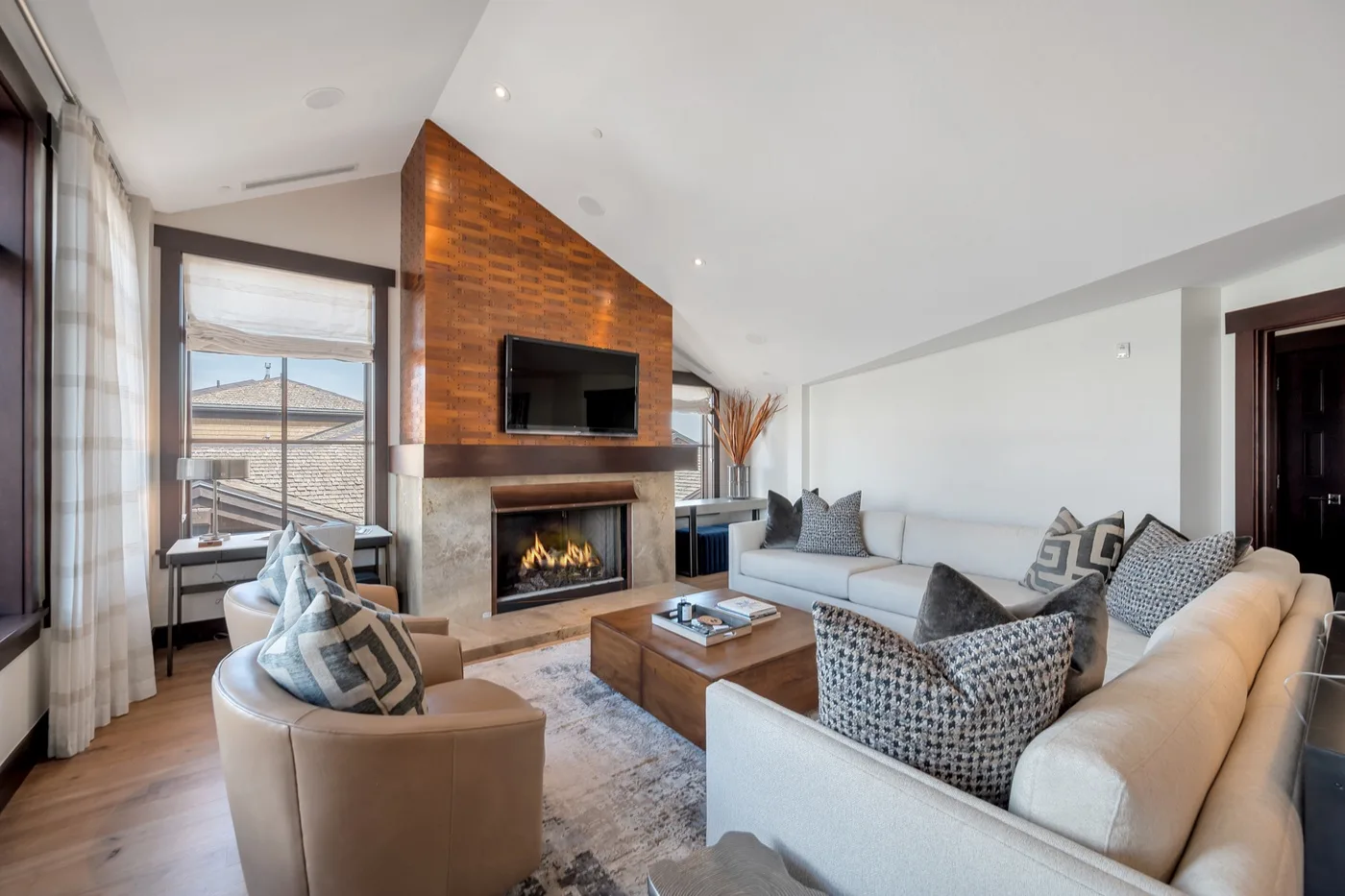 A bright living room with a brick fireplace and seating around a coffee table.