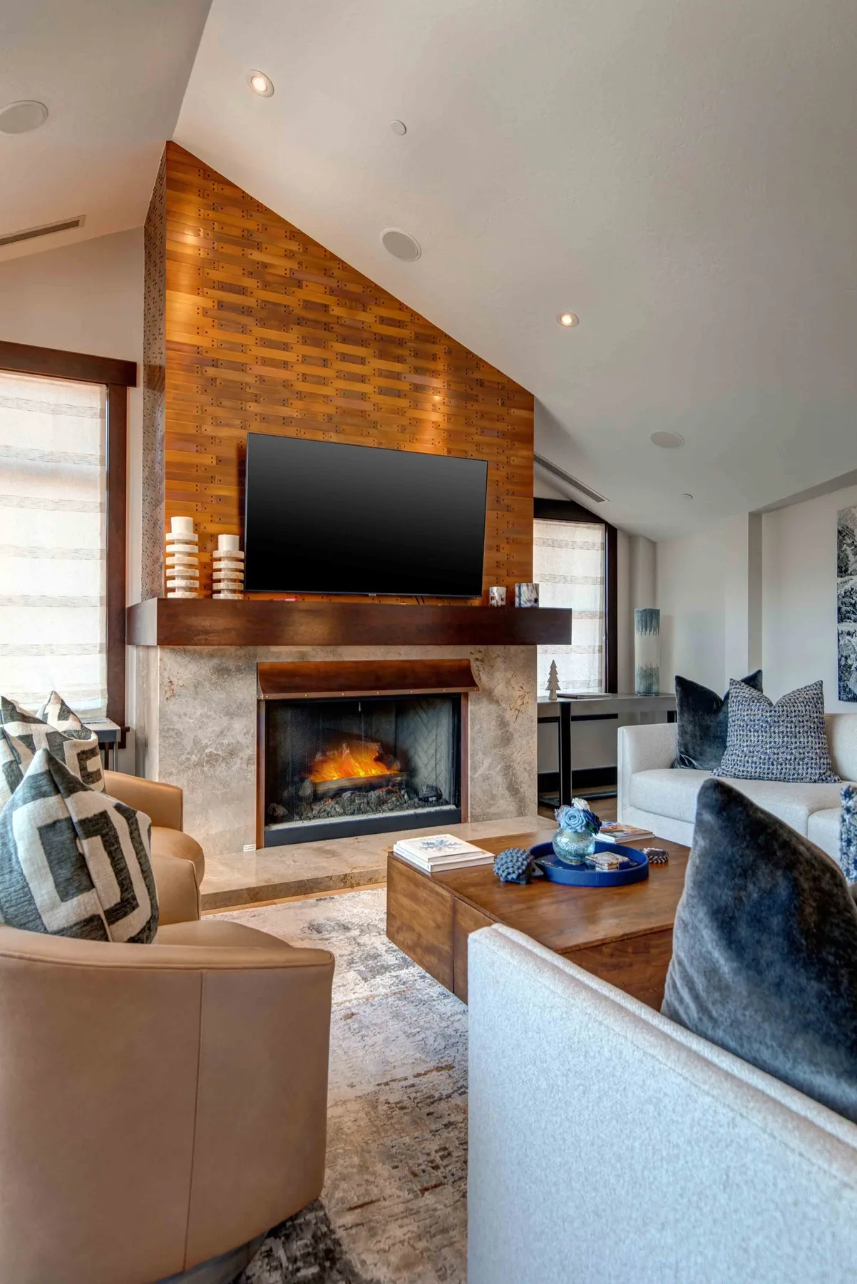 A bright living room features a fireplace beneath a wall-mounted television.