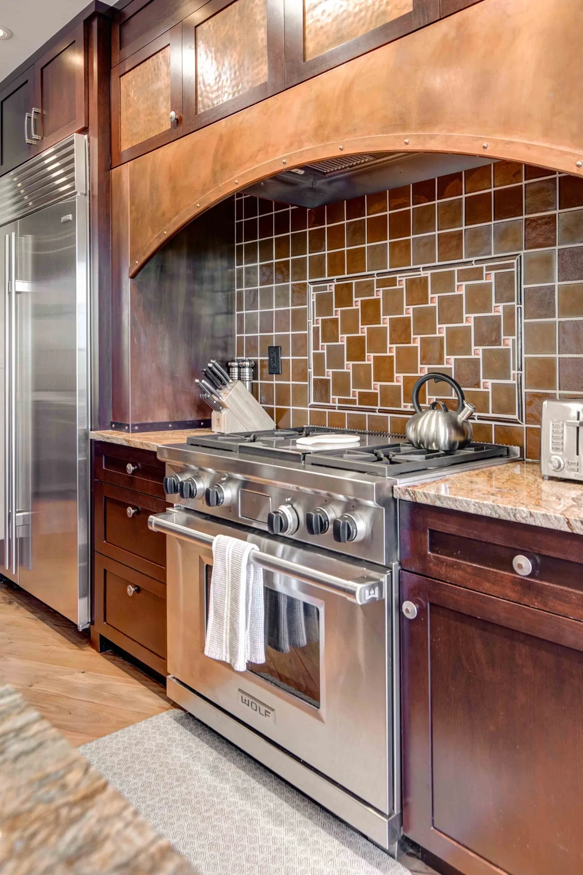 A kitchen with a stainless steel range beneath a tiled backsplash.
