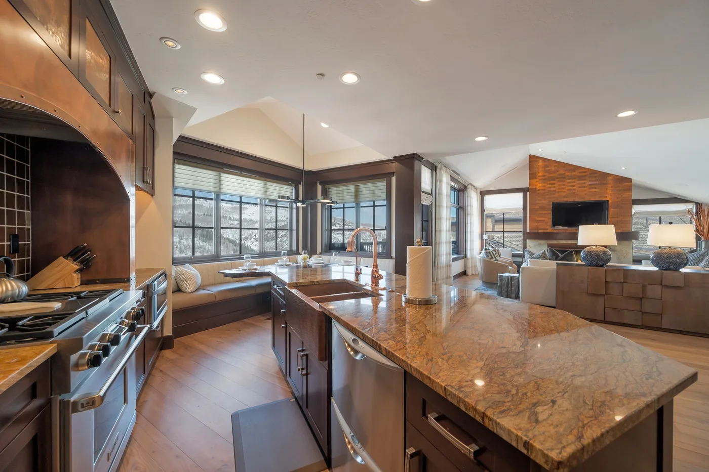 An open-plan kitchen and living area features a large island and broad windows.