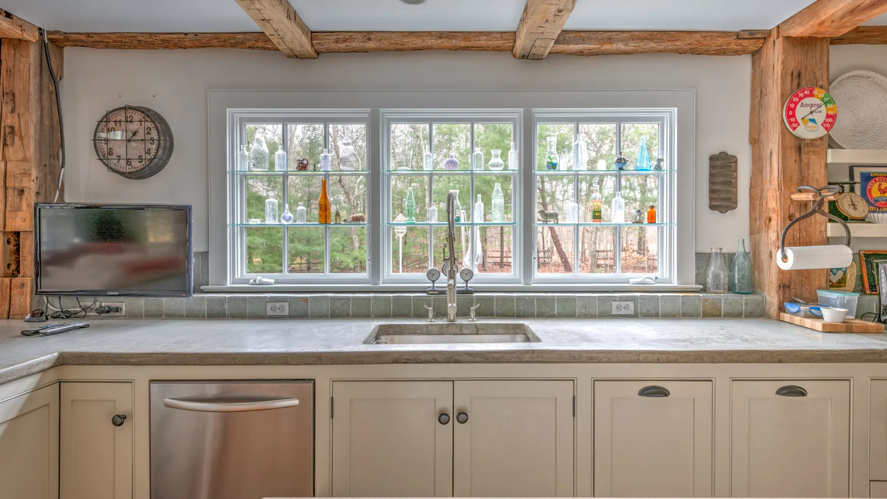 Una cocina luminosa con una encimera amplia, fregadero y ventanas encima.