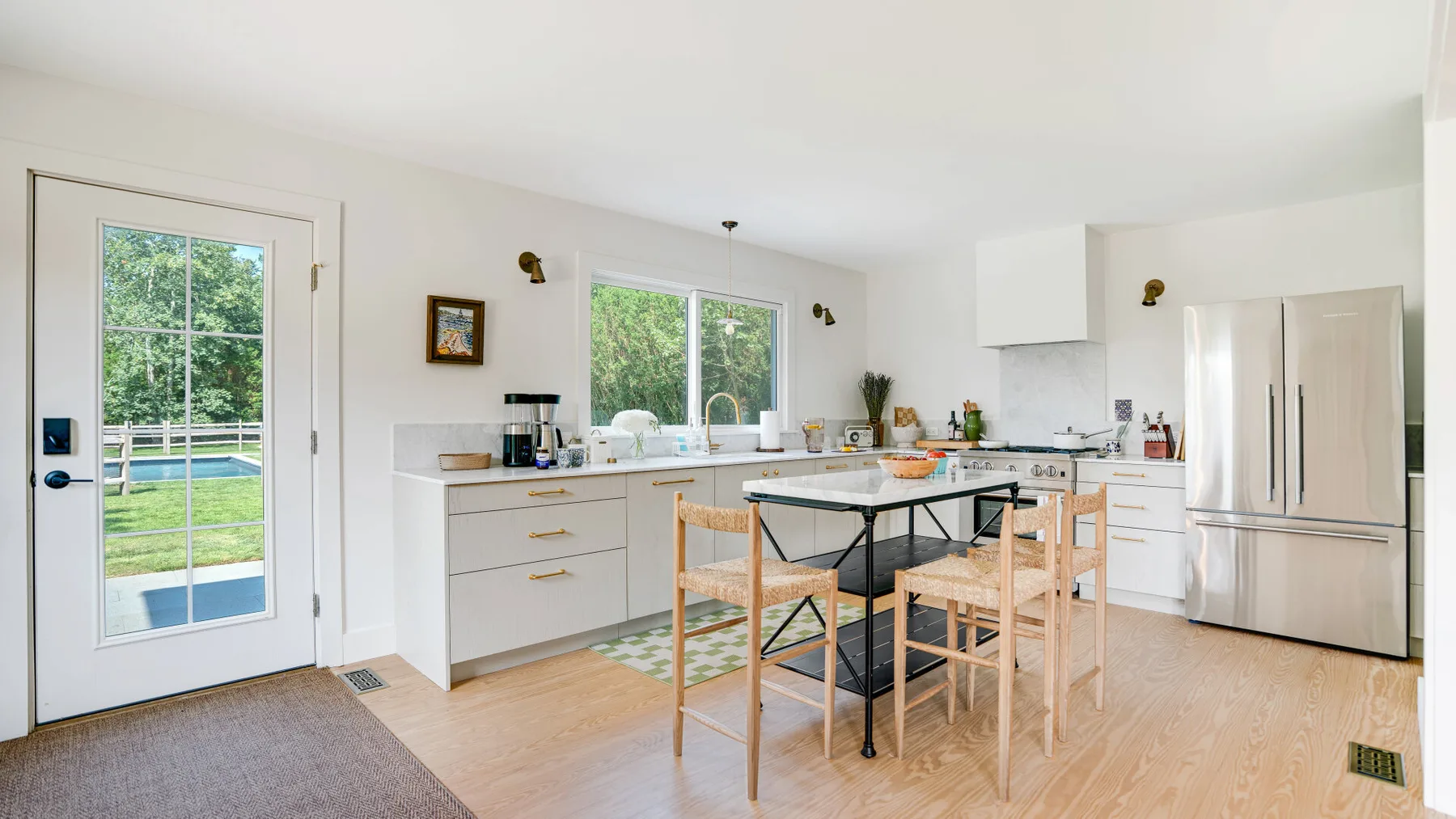 A bright kitchen and dining area with a table and large windows.