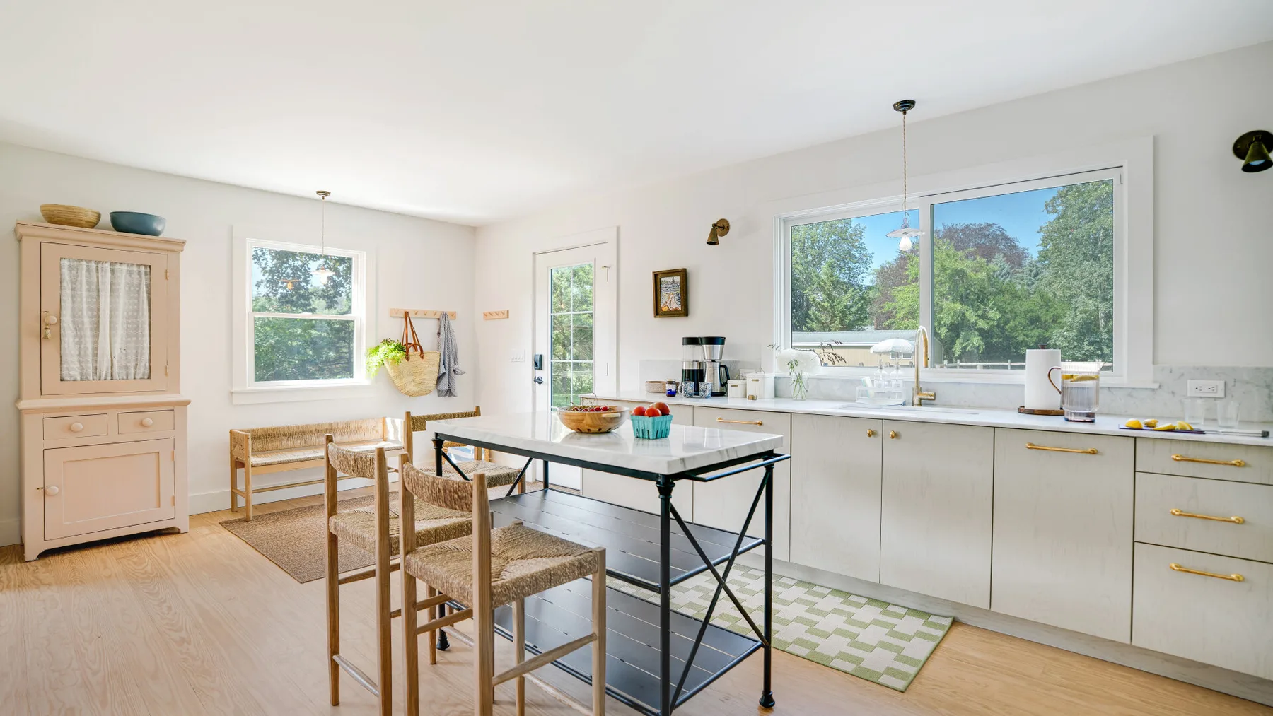 A bright kitchen with a dining table and large windows.