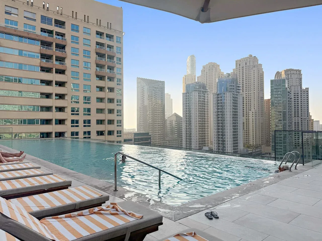 Una piscina al aire libre tiene vistas a un conjunto de edificios altos.