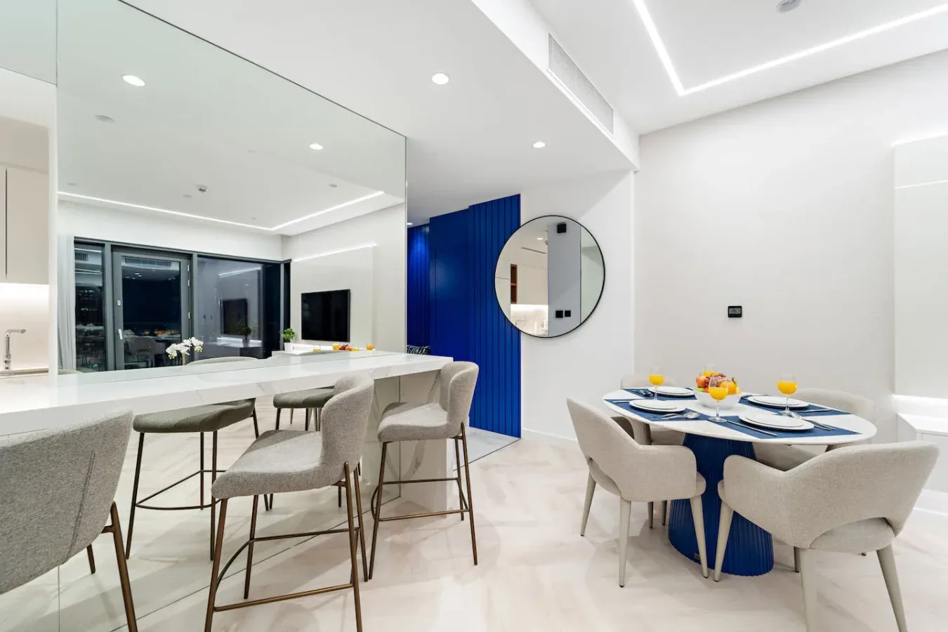 Un comedor luminoso con una mesa puesta junto a una encimera de cocina.