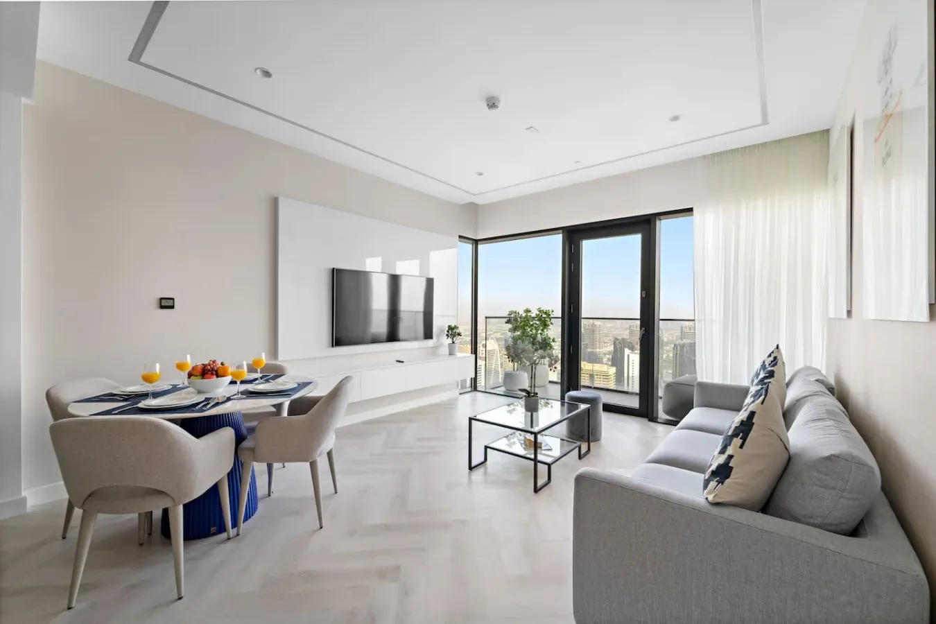 Una luminosa sala de estar y comedor con televisor, mesa de comedor y ventanales.