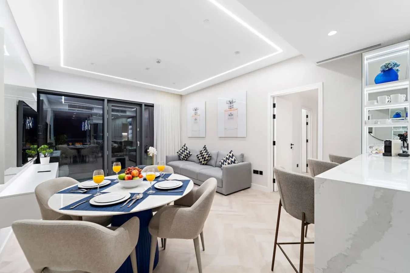 Un comedor luminoso con la mesa puesta junto a una barra de cocina.