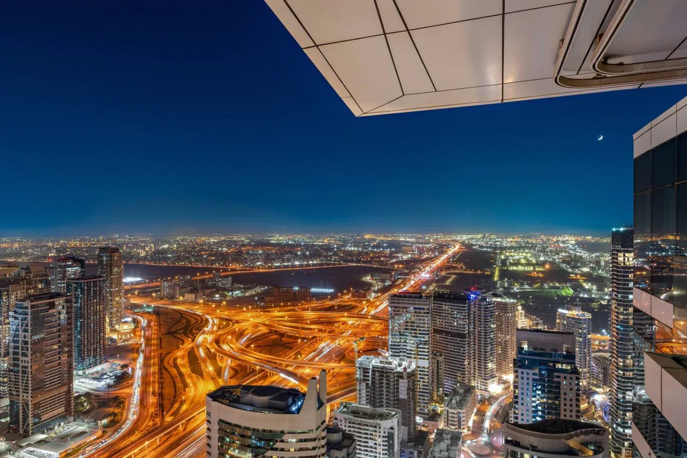 Un horizonte urbano nocturno con carreteras y edificios iluminados.