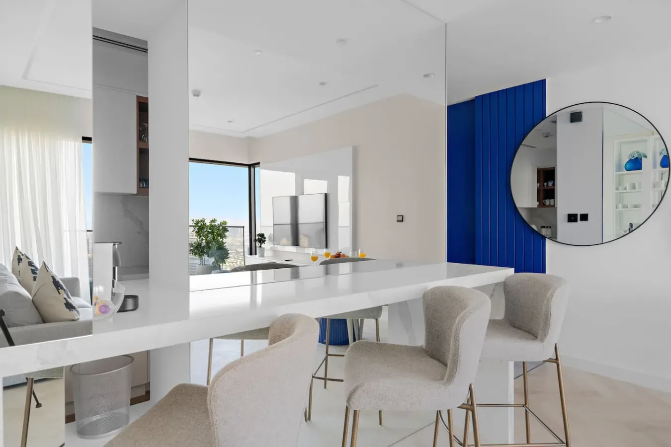 Una cocina y comedor modernos y luminosos, con una isla larga y asientos tapizados.